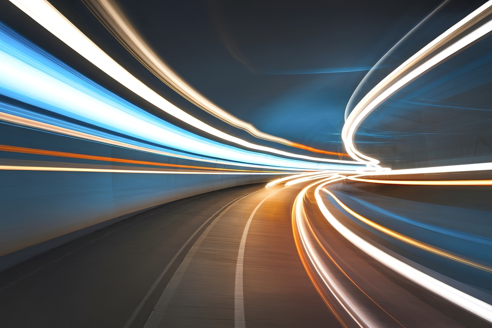 A long-exposure photograph of converging light trails, representing the collapse of separate brand and performance budgets into a single, high-velocity media architecture.