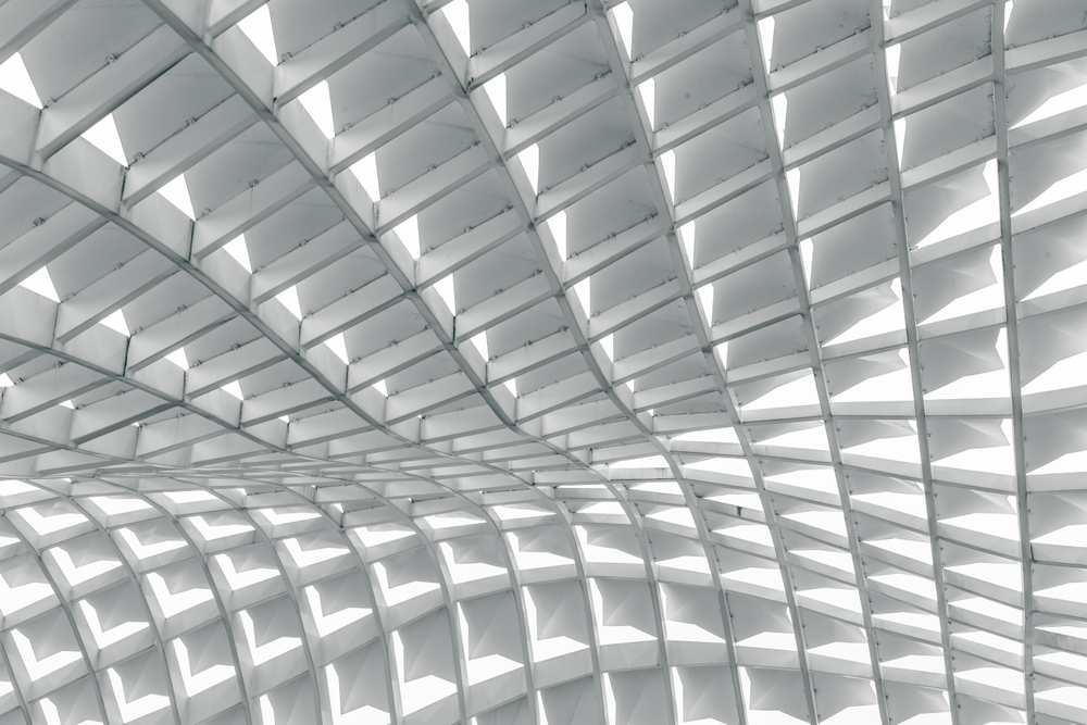 High-contrast architectural photograph of a curving white structural grid ceiling, serving as a visual metaphor for the recommendation surface and choice networks inside generative AI answers.